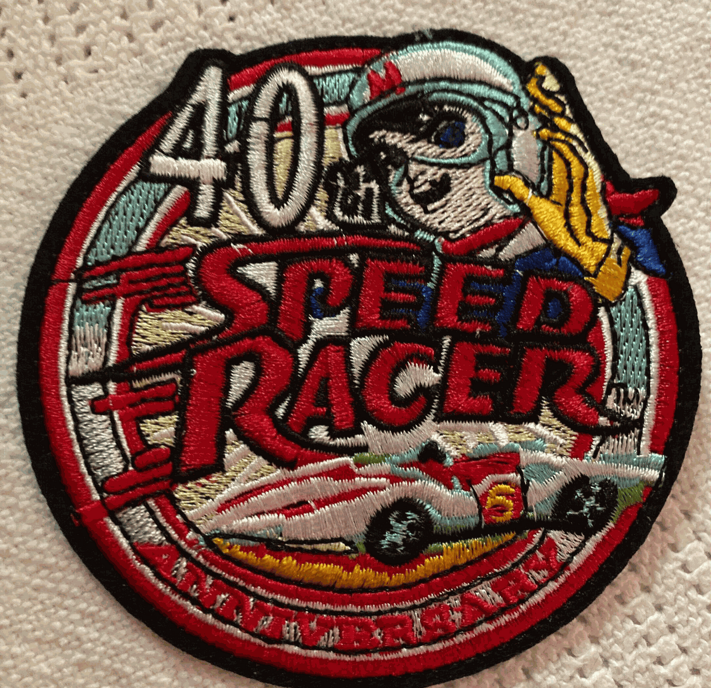 Speed Racer 40th Anniversary embroidered patch with cartoon racer, racing car, and bold text design