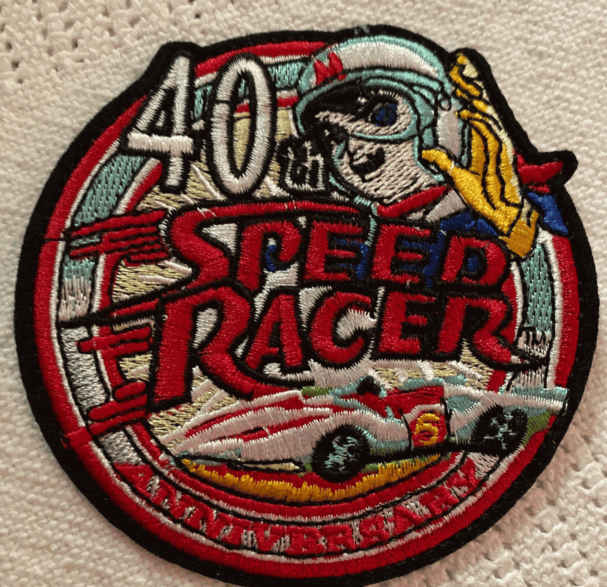 Speed Racer 40th Anniversary embroidered patch with cartoon racer, racing car, and bold text design