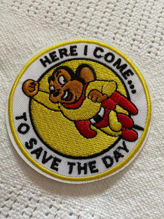 Embroidered Mighty Mouse patch with flying superhero design and text "Here I come to save the day" on a white background