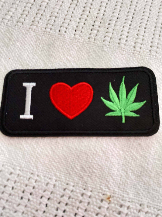 I Heart Cannabis embroidered patch with a red heart and green cannabis leaf on black background