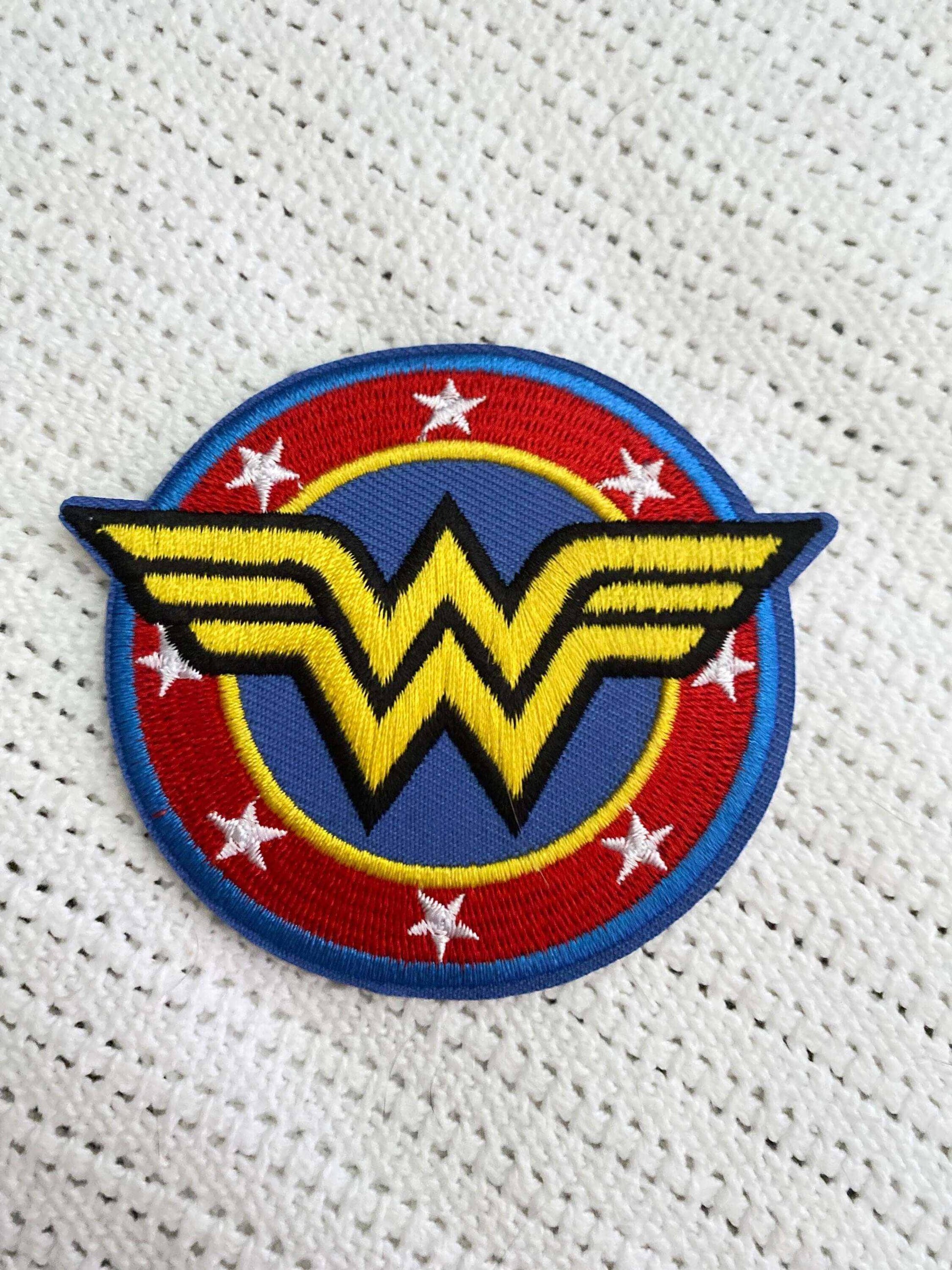 Embroidered Wonder Woman logo patch with yellow "W" and stars on red and blue background symbolizing female empowerment and gender equality