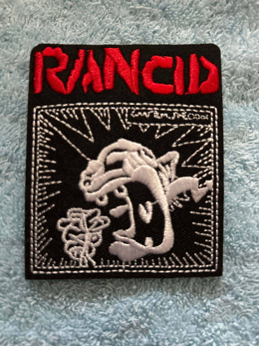 Rancid logo patch embroidered with red band name and black and white punk design on black background