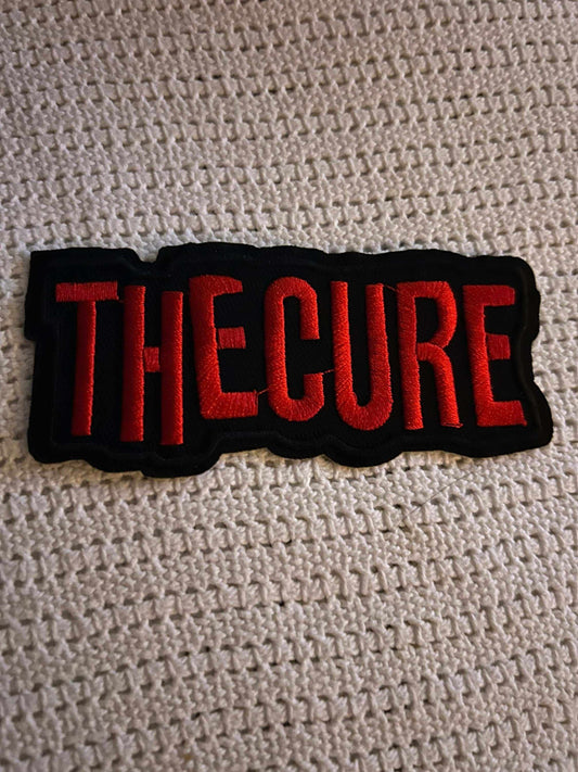Embroidered TheCure patch with bold red lettering on black background for fans of the English rock band.