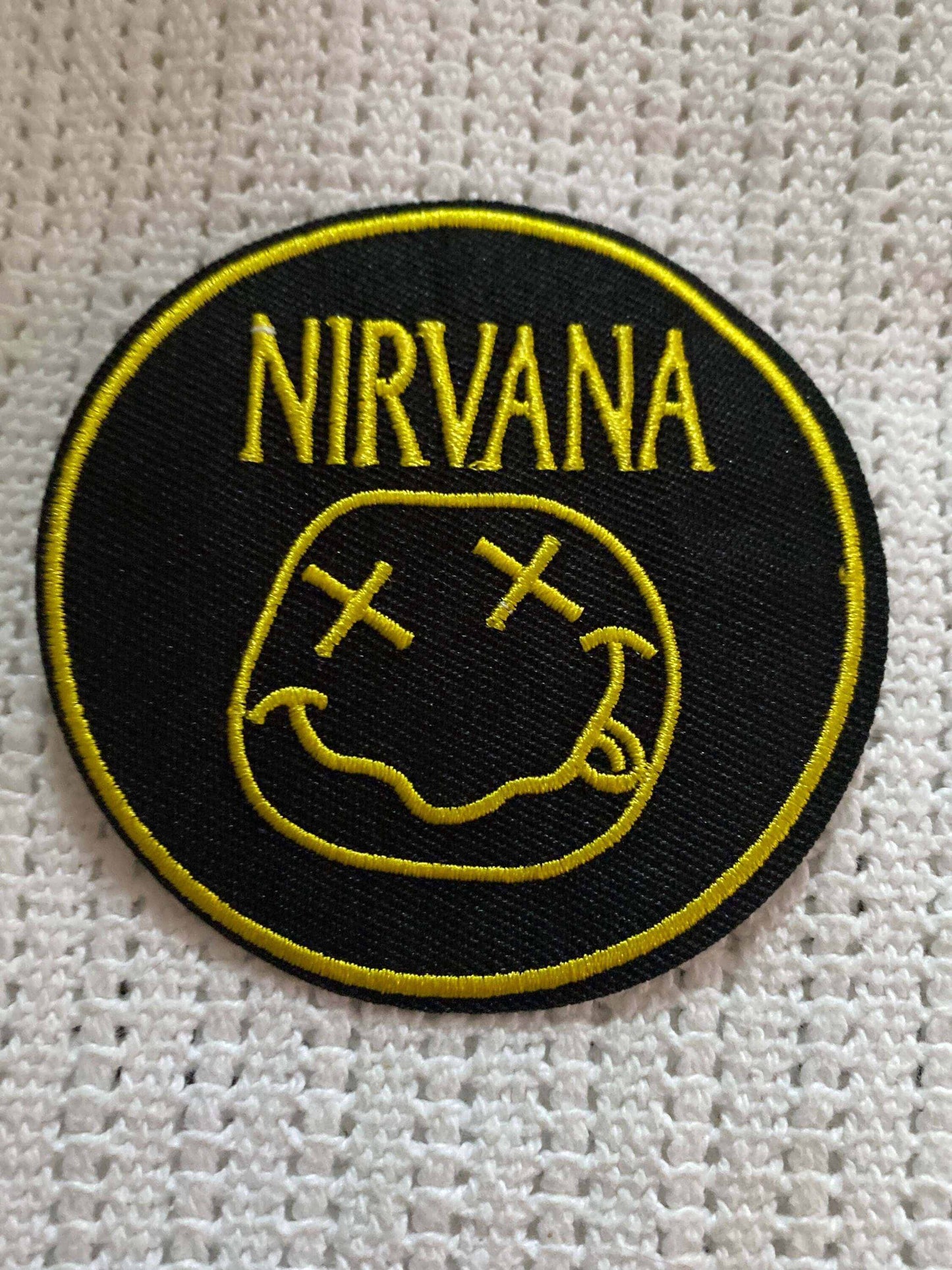 Nirvana band logo patch with yellow smiley face on black background