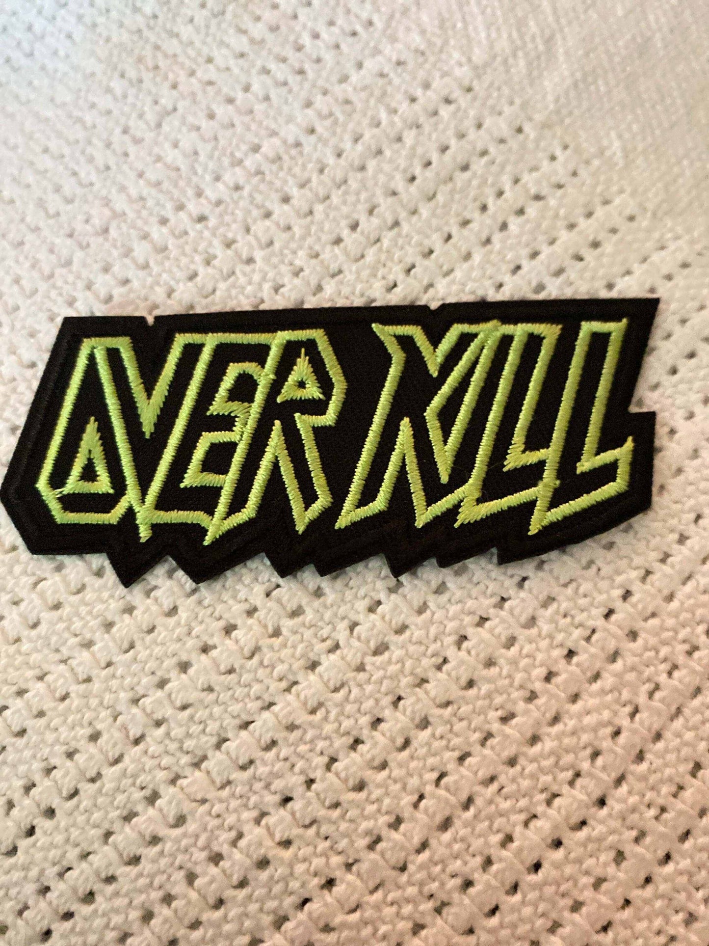 Over Kill embroidered patch with bold yellow-green outlined text on black background