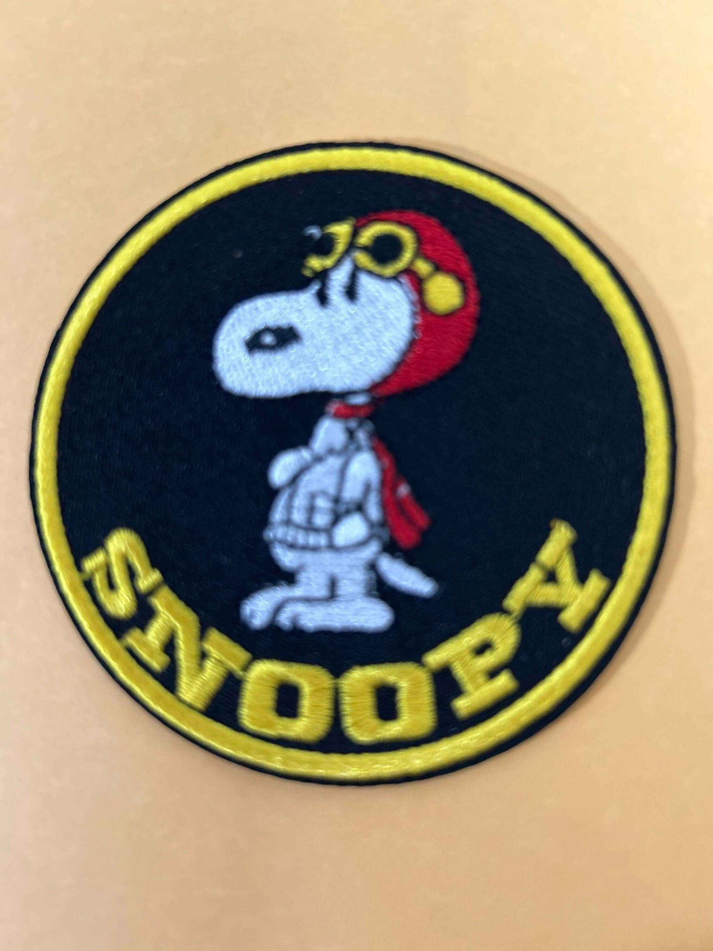Snoopy Red Baron patch embroidered with Snoopy in aviator hat and goggles, featuring yellow text on black background.
