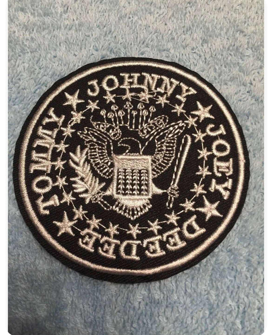 Black and white embroidered Ramones patch featuring band members' names and eagle emblem on fabric background